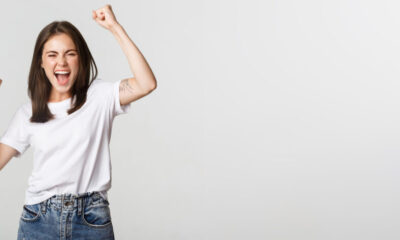 Cheerful attractive brunette girl fist pump and smiling with rejoice, winning