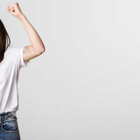 Cheerful attractive brunette girl fist pump and smiling with rejoice, winning