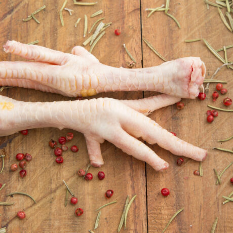 Chicken feet on the wooden background