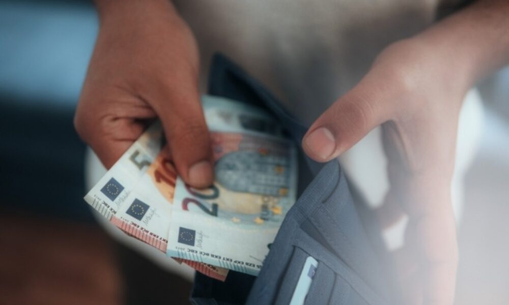 Young man holding in hands wallet with euro money