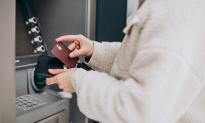 Woman withdrawing money at atm outside the street