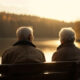 Senior couple sitting on bench enjoying sunset generated by AI