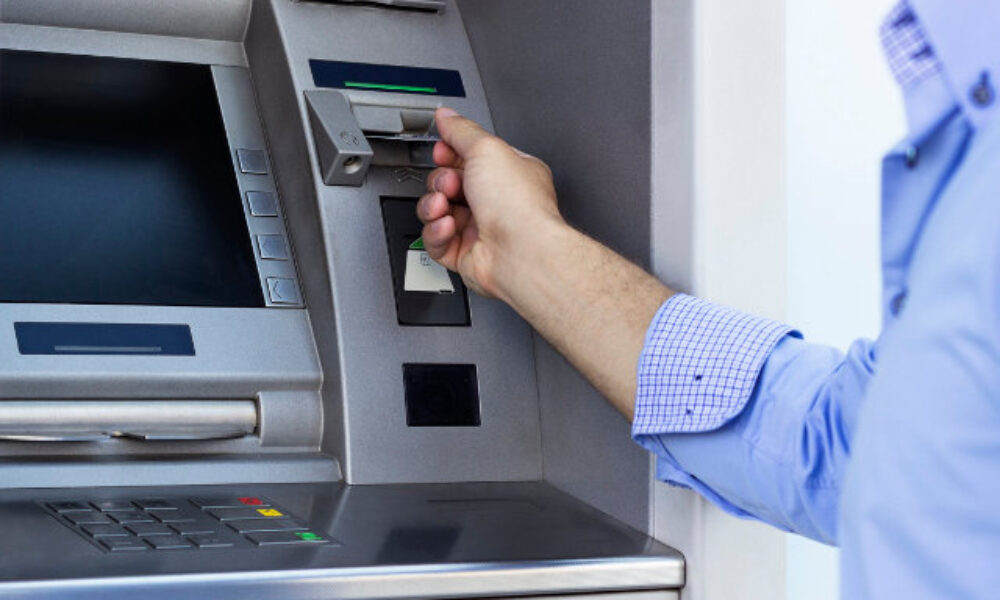 Hand of man with credit card, using a ATM