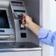 Hand of man with credit card, using a ATM