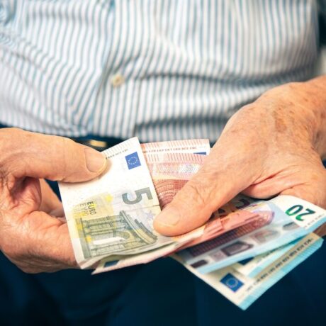 Old man sitting at home counting her money